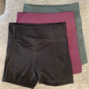 3 Girlfriend Collective High-Rise Run Shorts, Size Large, Black, Plum, and Moss